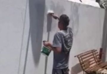 Homem é obrigado a pintar muro de praça após pichar local